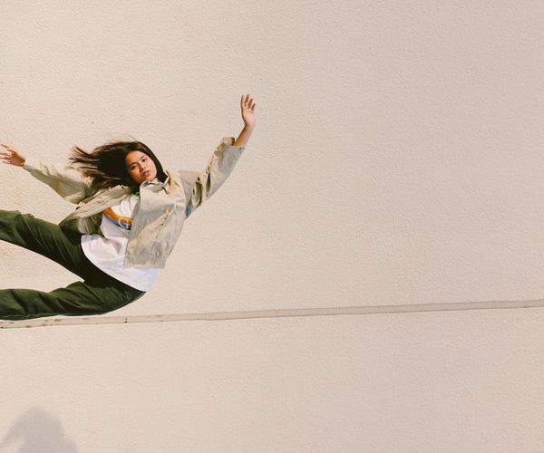 Person doing a warrior yoga pose against a minimal background.